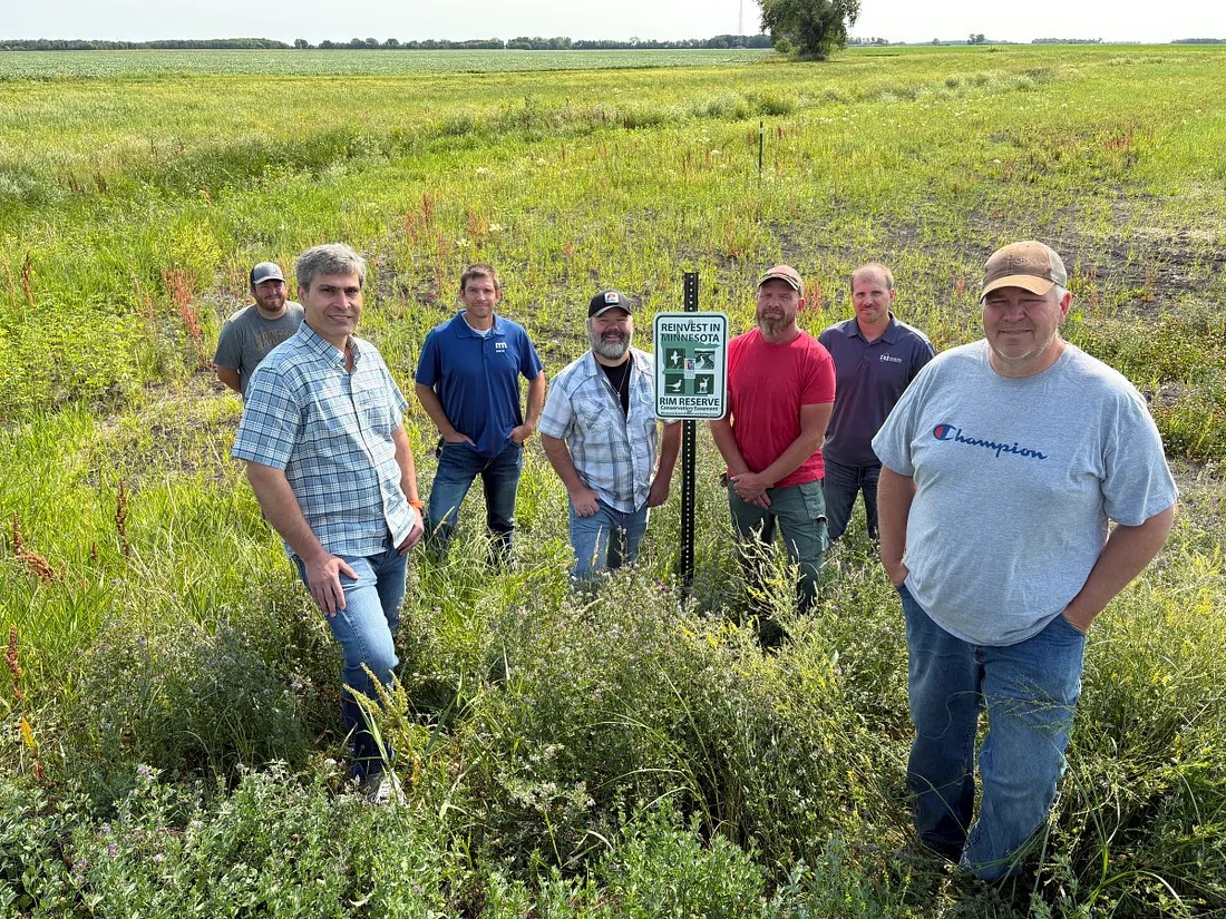 Members of the project team are photographed in front of a segment of the Swift Coulee.